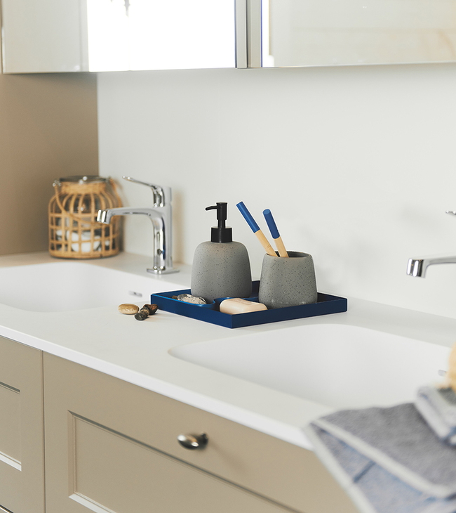 Blauwe badkamer accessoires op taupe badkamermeubel