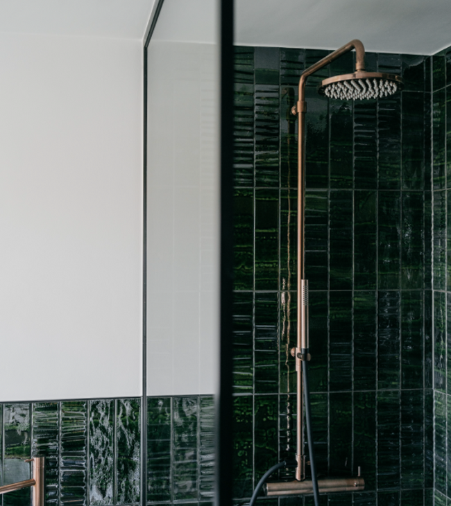 jaren 60 douche met groene tegels en bronskleurige regendouche