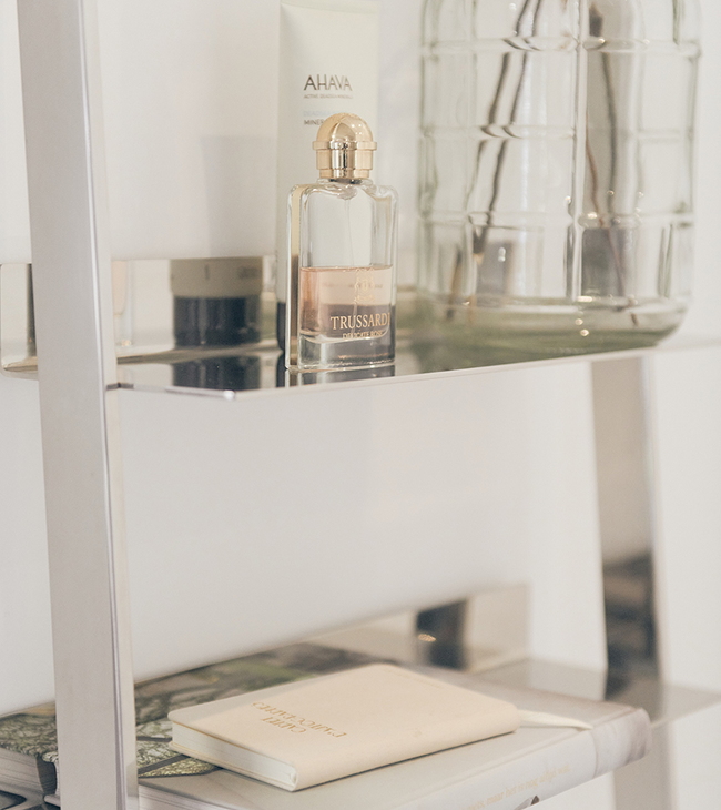 Ladderrek met accessoires in stijl country, met parfumflesje, verzorgingsproducten en decoratieve glazen fles.