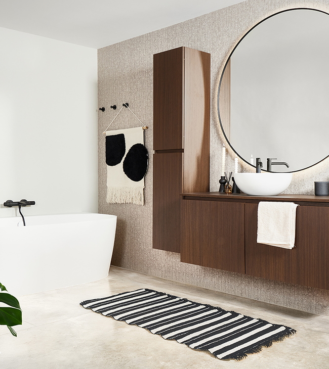 Basic badkamer met betonvloer, walnoot meubel en ronde spiegel