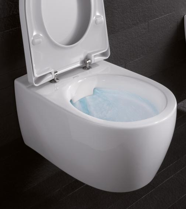 Wit hangend toilet met open deksel en spoelend water, geplaatst tegen een donkere tegelwand.