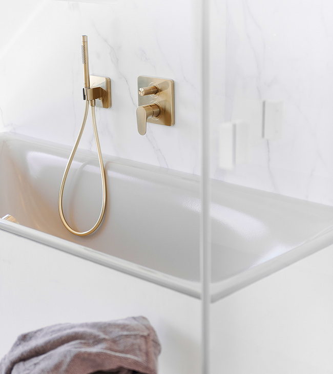 Bad met gouden kraan en marmerlook wandpaneel